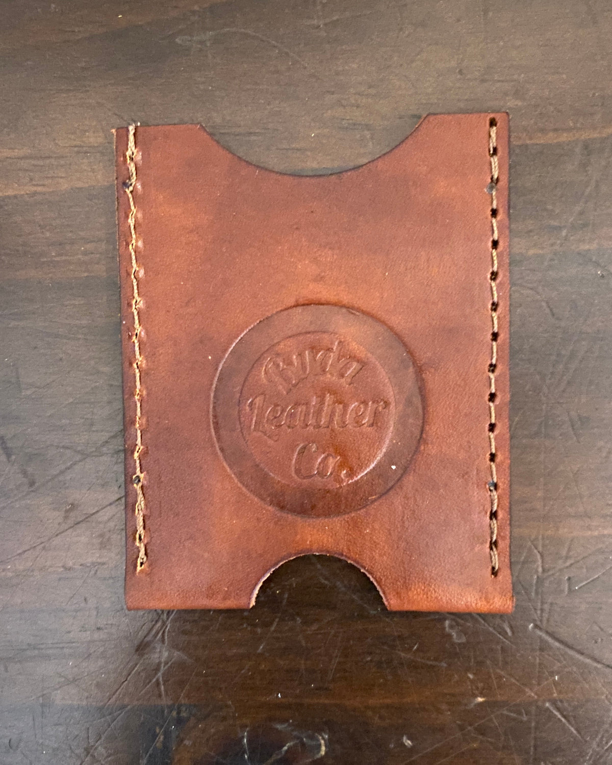 Buda Leather Co. handmade slim leather card wallet with stamped logo, measuring 3.5 inches by 2.5 inches.