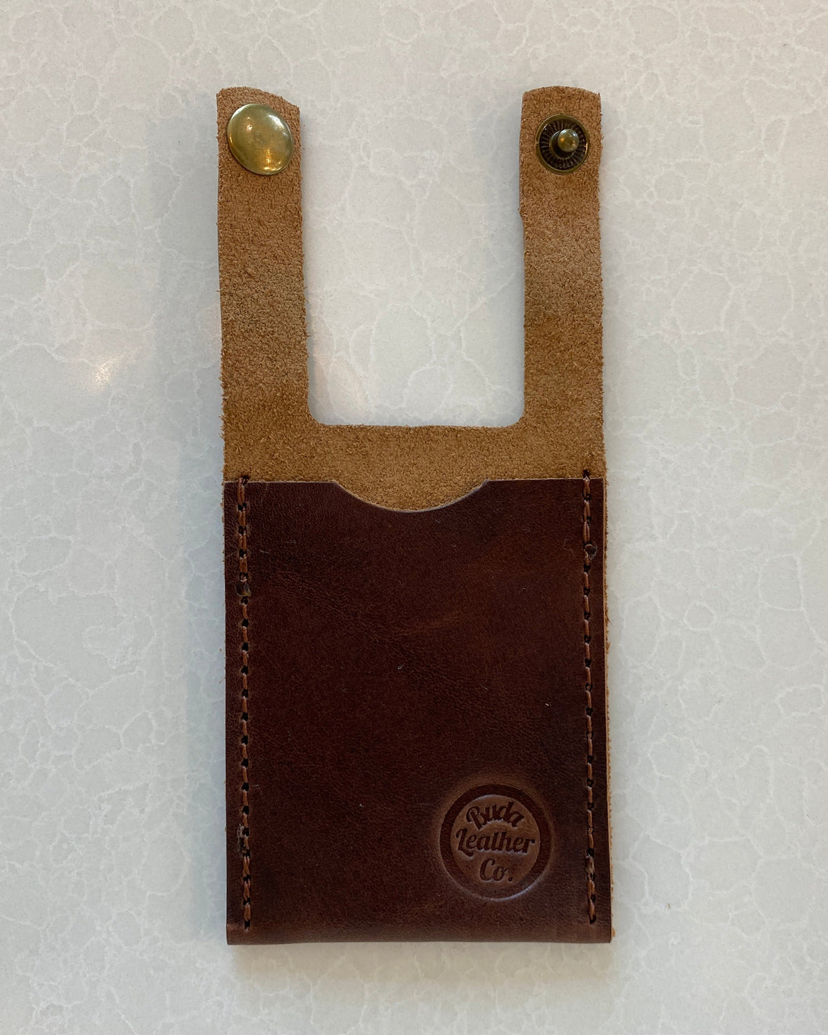 A dark brown leather boot wallet with a lighter tan leather top section and two brass snap buttons, featuring a debossed 'Buda Leather Co' logo on the bottom right.