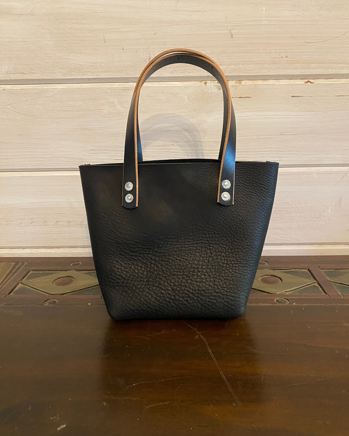 Buda Leather small tote made from pebbled black top-grain leather with stamped logo patch and silver hardware.